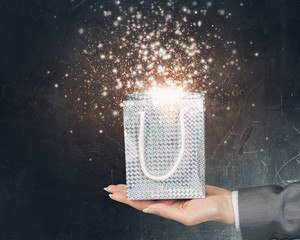 Woman presenting gift box . Mixed media