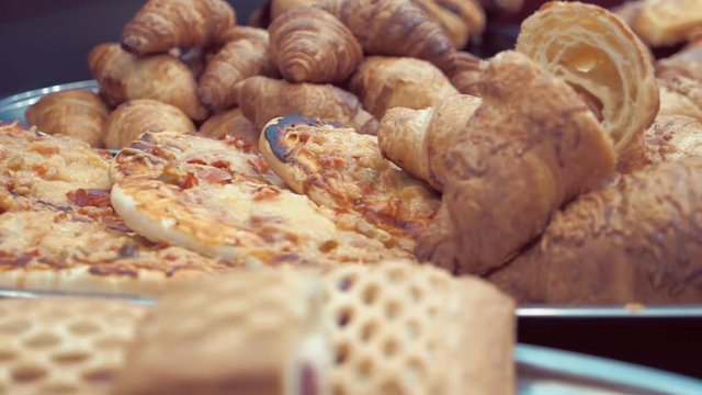 Croissants, pizza, rolls and other bakery products on store shelves