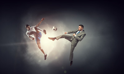 Obraz na płótnie Canvas Businessman kicking ball . Mixed media