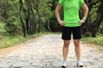 young woman trail runner in forest