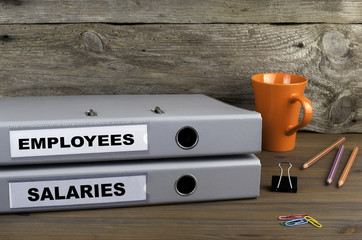 Employees and Salaries - two folders on wooden office desk