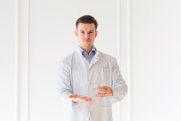 Doctor giving capsule and glass of water
