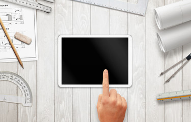 Tablet with blank screen for mockup on architect work desk. Construction projects, and drawing...