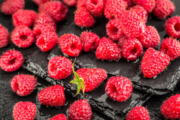 Fresh red raspberries on a slate background