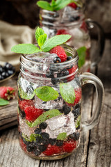 Detox drink with fresh berries in glass jars