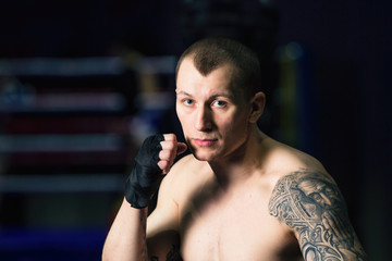 Sports: man kickboxer is practicing kick in a boxing gym