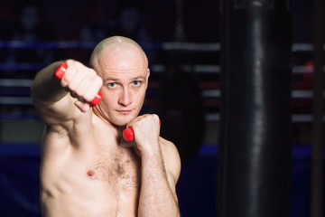 Sports: man kickboxer is practicing kick in a boxing gym