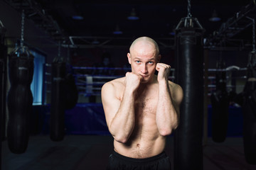Sports: man kickboxer is practicing kick in a boxing gym