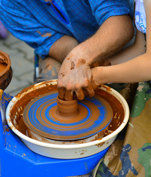Potter teaches to sculpt a baby from clay on a Potter's wheel