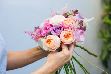 Florist at work: woman making fashion modern bouquet of different flowers