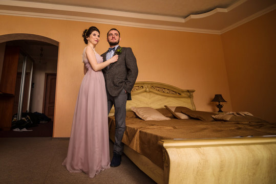 Man and woman standing near the bed at hotel