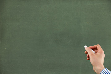 green chalkboard with hand holding chalk