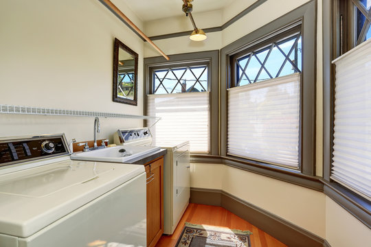 Old laundry room interior with white appliances and vintage windows.
