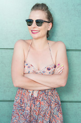 Happy girl wearing shades standing with arms crossed