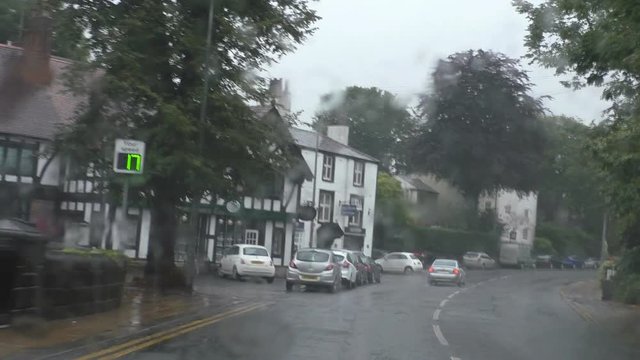 Driver POV while driving on busy road in the rain in English town of Worsley, Salford, Greater Manchester, UK