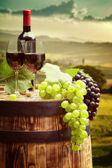 Naklejka na ściany i meble Red wine with barrel on vineyard in green Tuscany, Italy