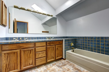 Bright bathroom with vaulted ceiling and blue tile wall trim