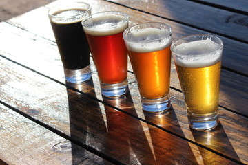 A selection of four craft beers during a tasting session on a wooden table