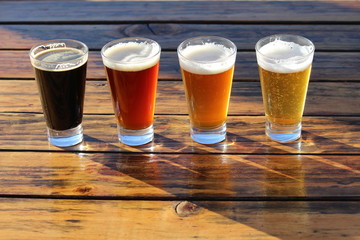 A selection of four craft beers during a tasting session on a wooden table