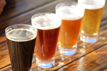 Een selectie van vier ambachtelijke bieren tijdens een proeverij op een houten tafel