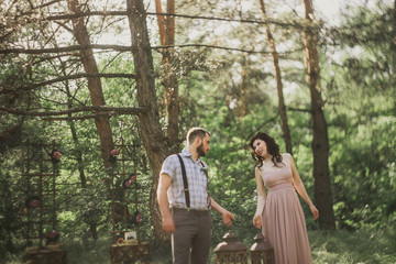 stylish couple pose in the sunlight wood near decor zone. Blurred and haze