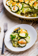 Casserole with zucchini, rice and cheese served with fresh basil