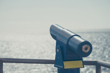 Tourist binoculars with ocean on background