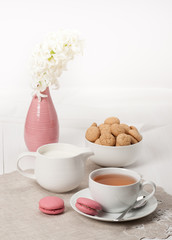 Hyacinth Flowers In Vase. Amaretti Biscuits. Cup Of Tea