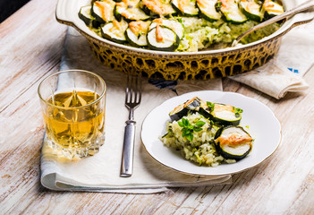 Casserole with zucchini, rice and cheese served with fresh basil