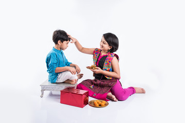 Pooja ceremony performed by cute looking sister and small brother on rakhi festival in India