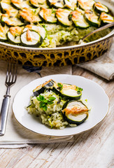 Casserole with zucchini, rice and cheese served with fresh basil