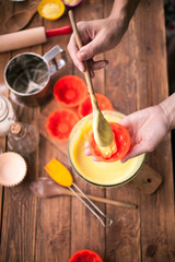 Female hands, ingredients and devices for preparation of cupcakes on a wooden background. House pastries. Food concept. Flour, eggs, butter, mix for pastries. Top view
