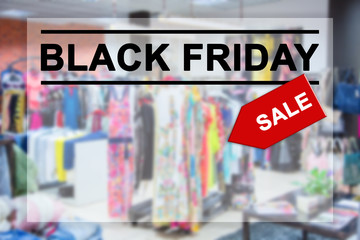 Black Friday text on blurred shopping mall background.