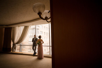 man and woman are standing near panoramic window