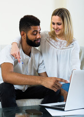 Fototapeta na wymiar young interracial couple near laptop
