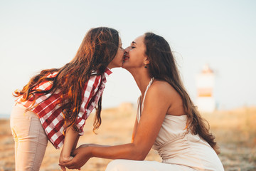 Child with mom walking on the beach