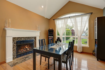 American dining room interior with black table set and fireplace.