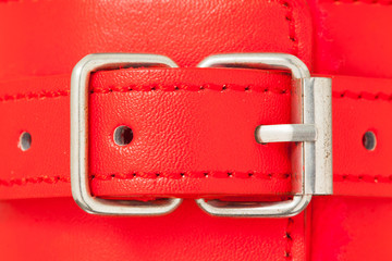 Close up of buckle belt on a BDSM leather red handcuffs.