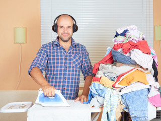 Caucasian man ironed clothes in the room near the window and lis © volkovslava