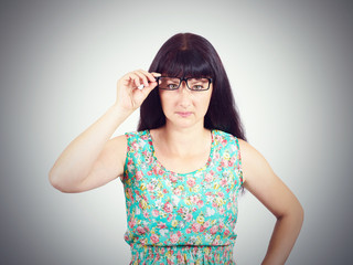 Young women look with suspicion through her glasses