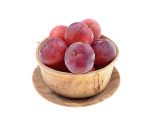 Sweet red plum in a wooden bowl  isolated on white background .