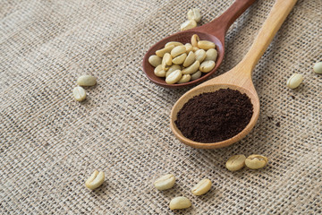 Coffee in wooden spoon on sackcloth background.