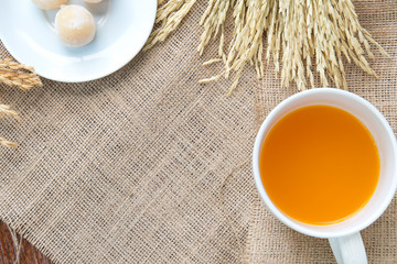 Orange juice and sweets with rice drying on Sackcloth brown back
