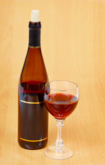 Bottle of red wine and glass on wooden table
