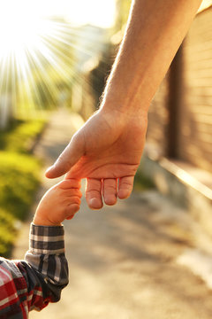  parent holds the hand of a small child