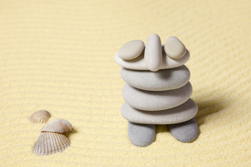 Fototapeta na wymiar Amusing figure of man from pebble on sand