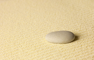 Fototapeta na wymiar Element of Japanese rock-garden - stone on sand