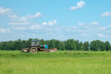 Fototapeta premium Old tractor goes through field