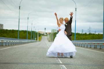 Fototapeta na wymiar Newly married have fun on highway