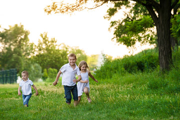Fototapeta na wymiar Three children run a race in the park